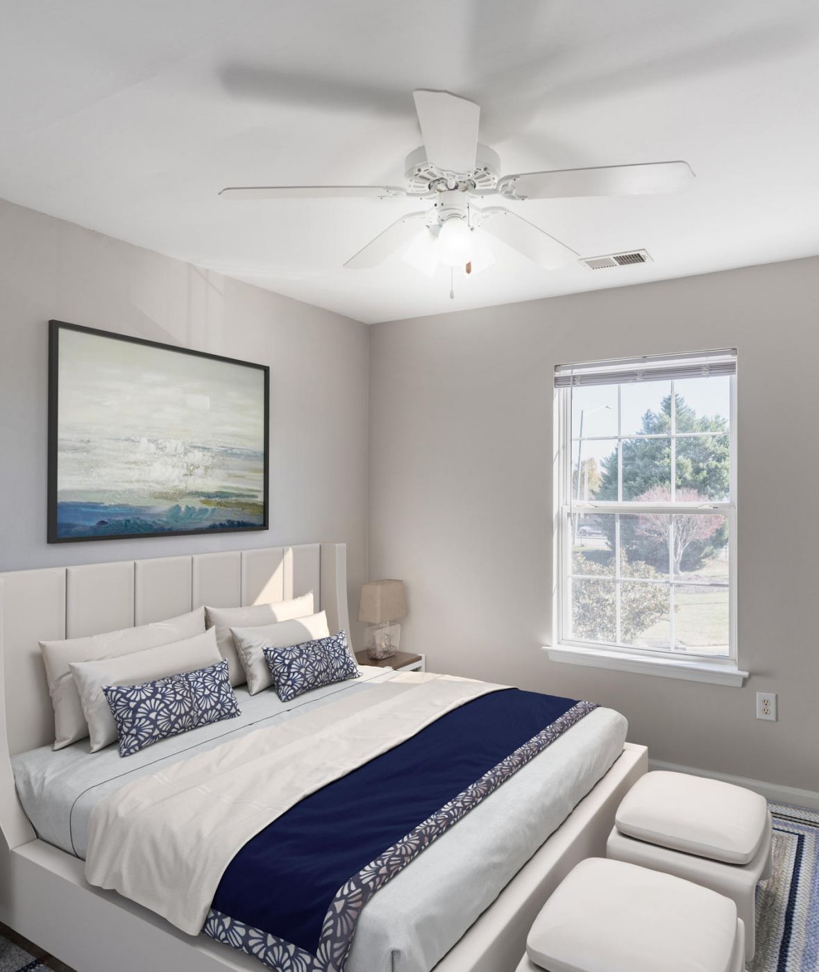 Attain on 5th apartment homes with A bright bedroom with a bed, artwork above the headboard, and sunlight coming through a window.