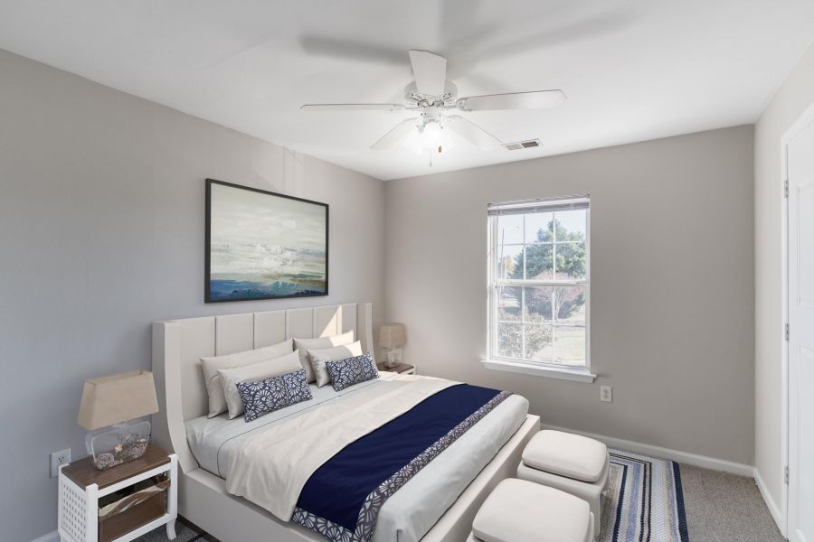 Attain on 5th apartment homes with A bright bedroom with a bed, artwork above the headboard, and sunlight coming through a window.